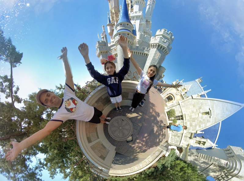 Familia viajera en Disney frente al castillo